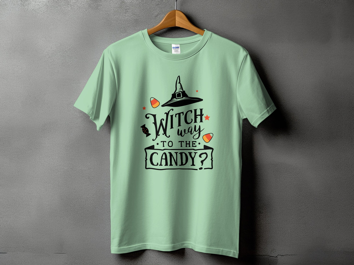 Light green t-shirt with black Halloween graphic and text: Witch way to the candy?