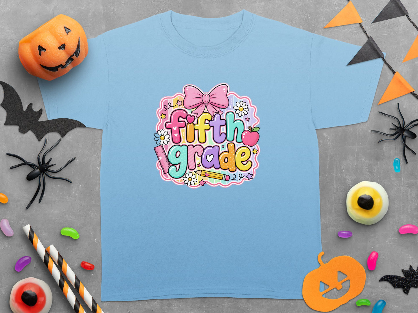 Light blue t-shirt with "fifth grade" text surrounded by pastel school and Halloween decorations.