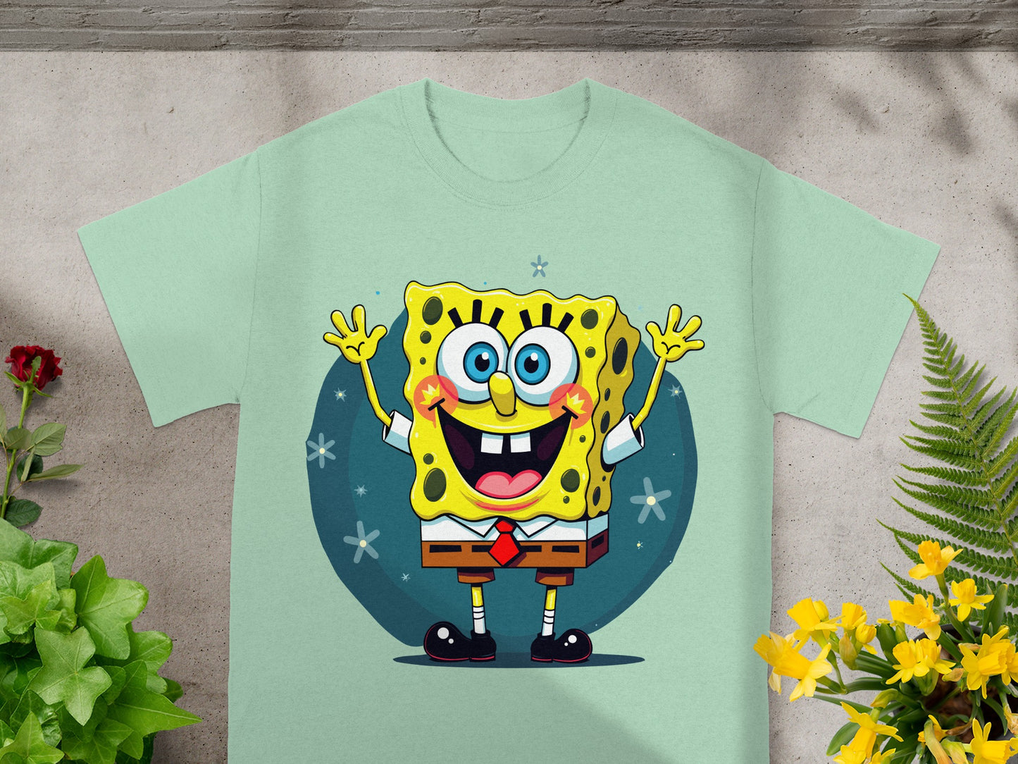 SpongeBob SquarePants character with arms raised and smiling on a mint green t-shirt.