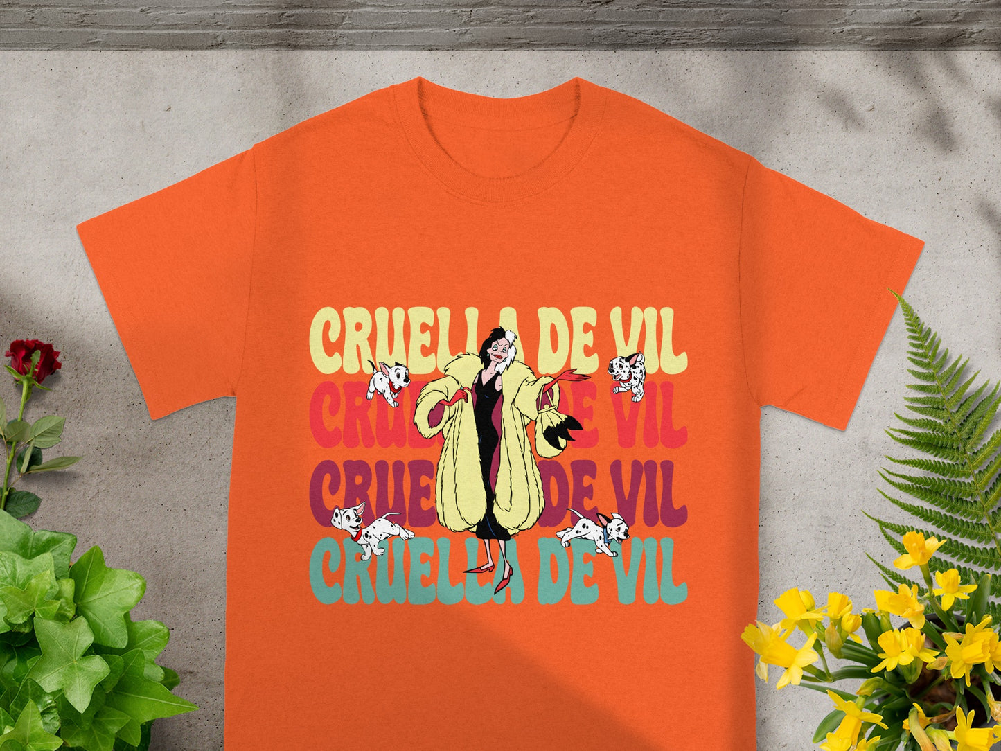 Orange t-shirt with Cruella de Vil graphic and "CRUELLA DE VIL" text.