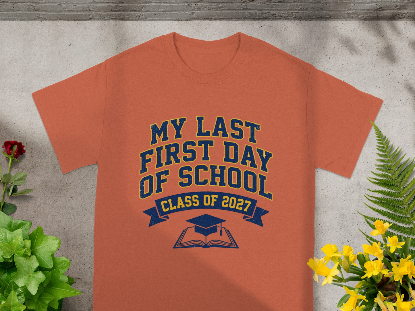 Orange t-shirt with "My Last First Day Of School Class Of 2027" text and graphics.