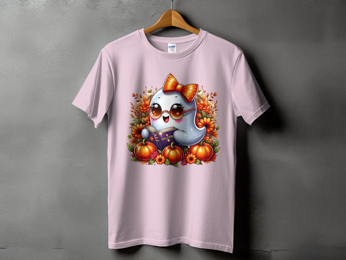 Pink t-shirt with cute ghost, sunglasses, bow, pumpkins, and book with "HALLOSTER" text.