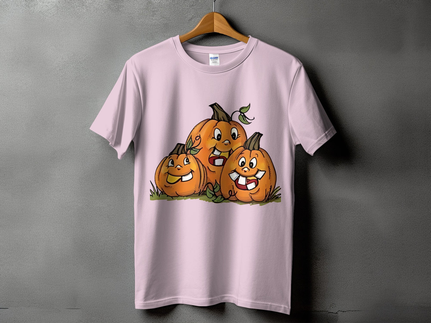 Pink t-shirt with cartoon illustration of three happy jack-o'-lanterns.