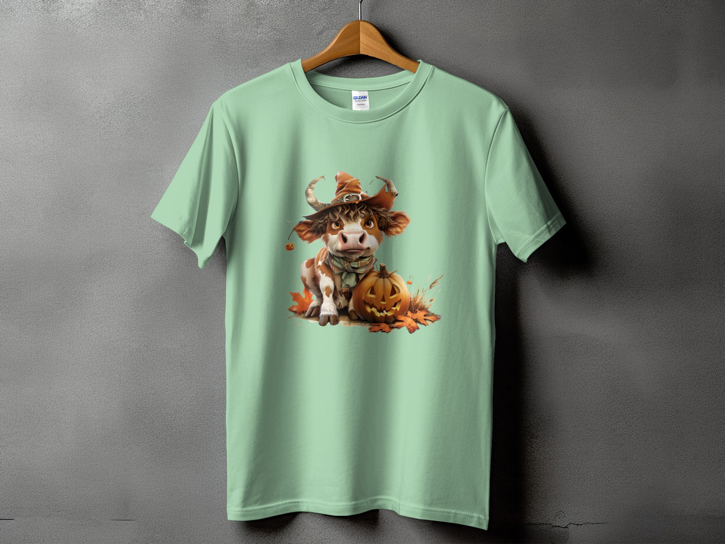 Mint t-shirt with a cute cow in a witch hat and pumpkin graphic.