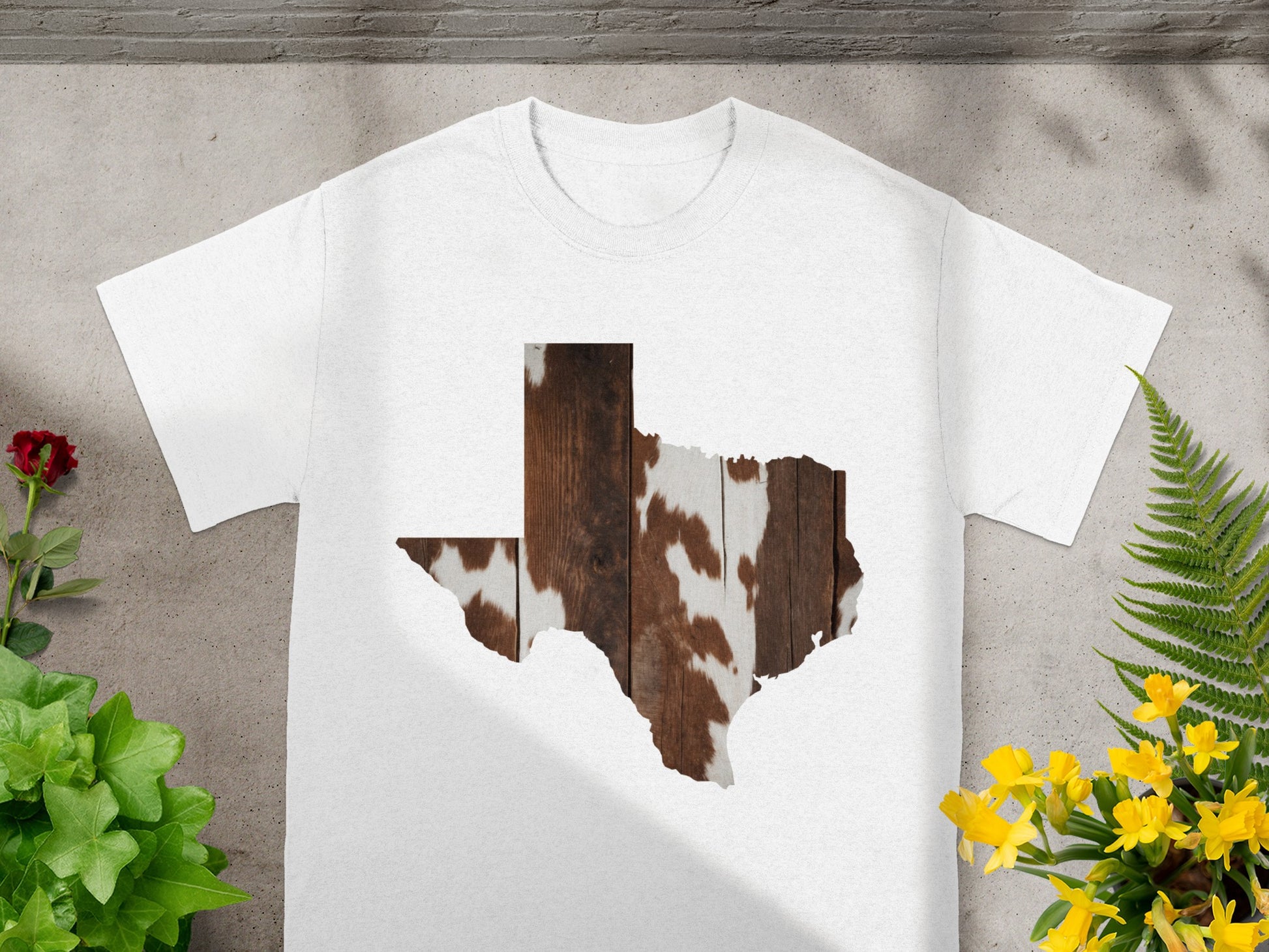 White t-shirt with Texas shape graphic of wood and cowhide.