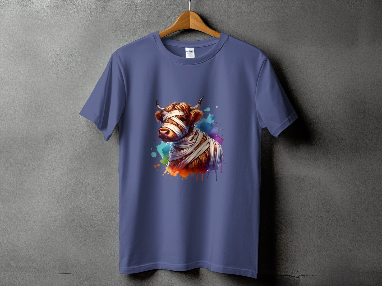 Mummy highland cow with colorful paint splatters graphic on a purple t-shirt.