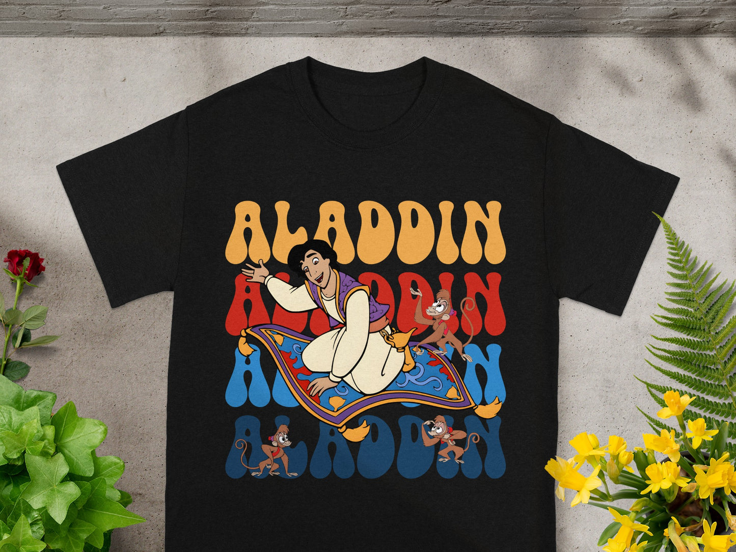 Aladdin and Abu on magic carpet with "Aladdin" text.