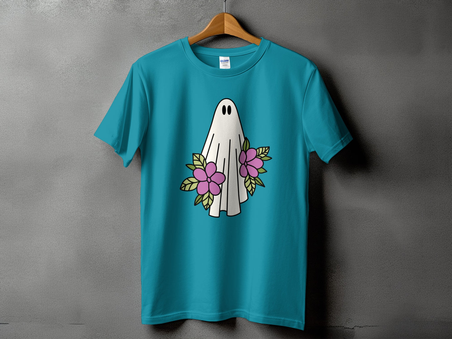 Teal t-shirt with a white cartoon ghost and pink flowers graphic.