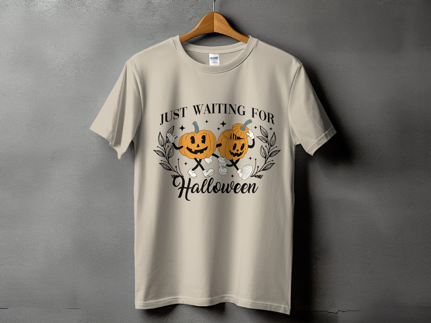 Light beige t-shirt with cartoon pumpkins saying "JUST WAITING FOR Halloween".