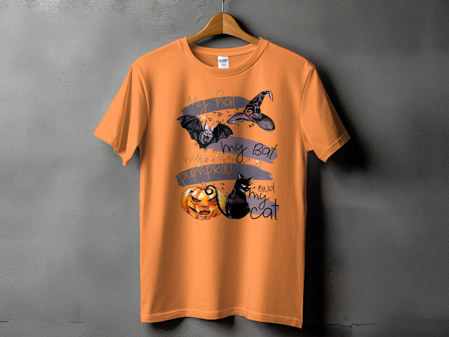 Orange t-shirt with Halloween graphic of a bat, witch hat, pumpkin, and cat.