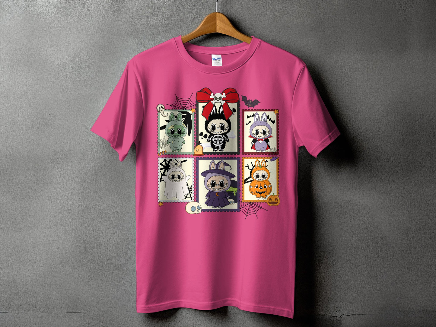 Pink t-shirt with six Halloween-themed postage stamp graphics featuring cartoon characters.