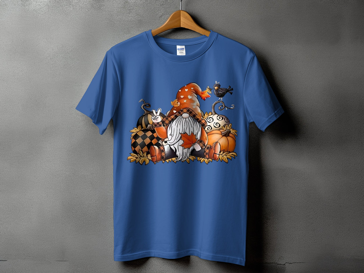 Blue t-shirt with a fall-themed graphic featuring gnomes, pumpkins, and a bird.