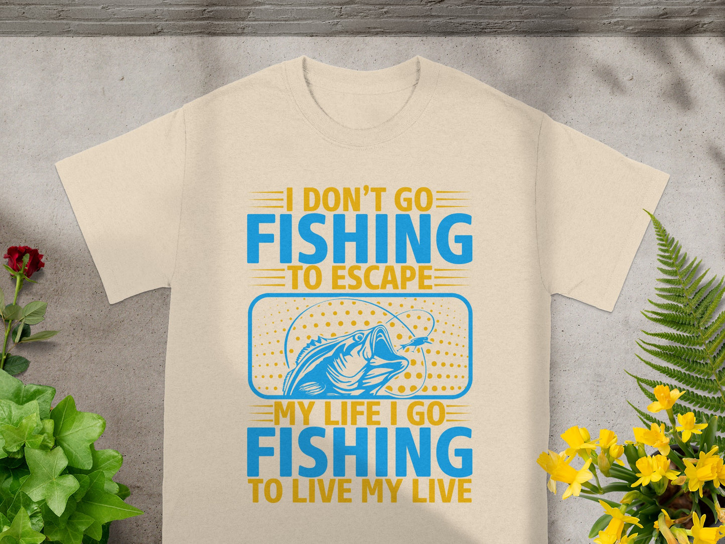 Cream t-shirt with blue and yellow text: "I DON'T GO FISHING TO ESCAPE MY LIFE. I GO FISHING TO LIVE MY LIVE."