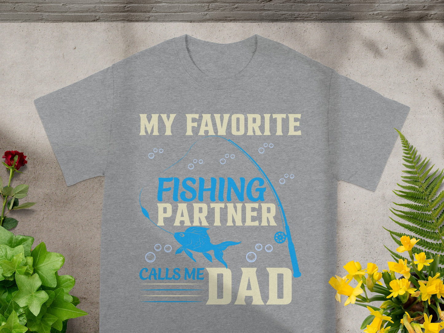 Grey t-shirt with "MY FAVORITE FISHING PARTNER CALLS ME DAD" text and fish graphic.