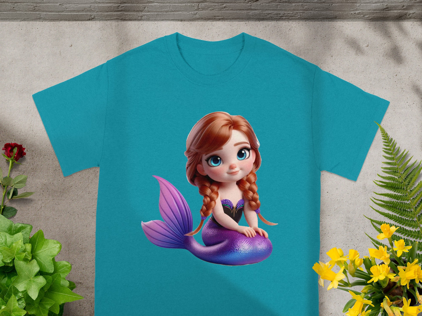 Turquoise t-shirt with a cartoon mermaid graphic on the front.