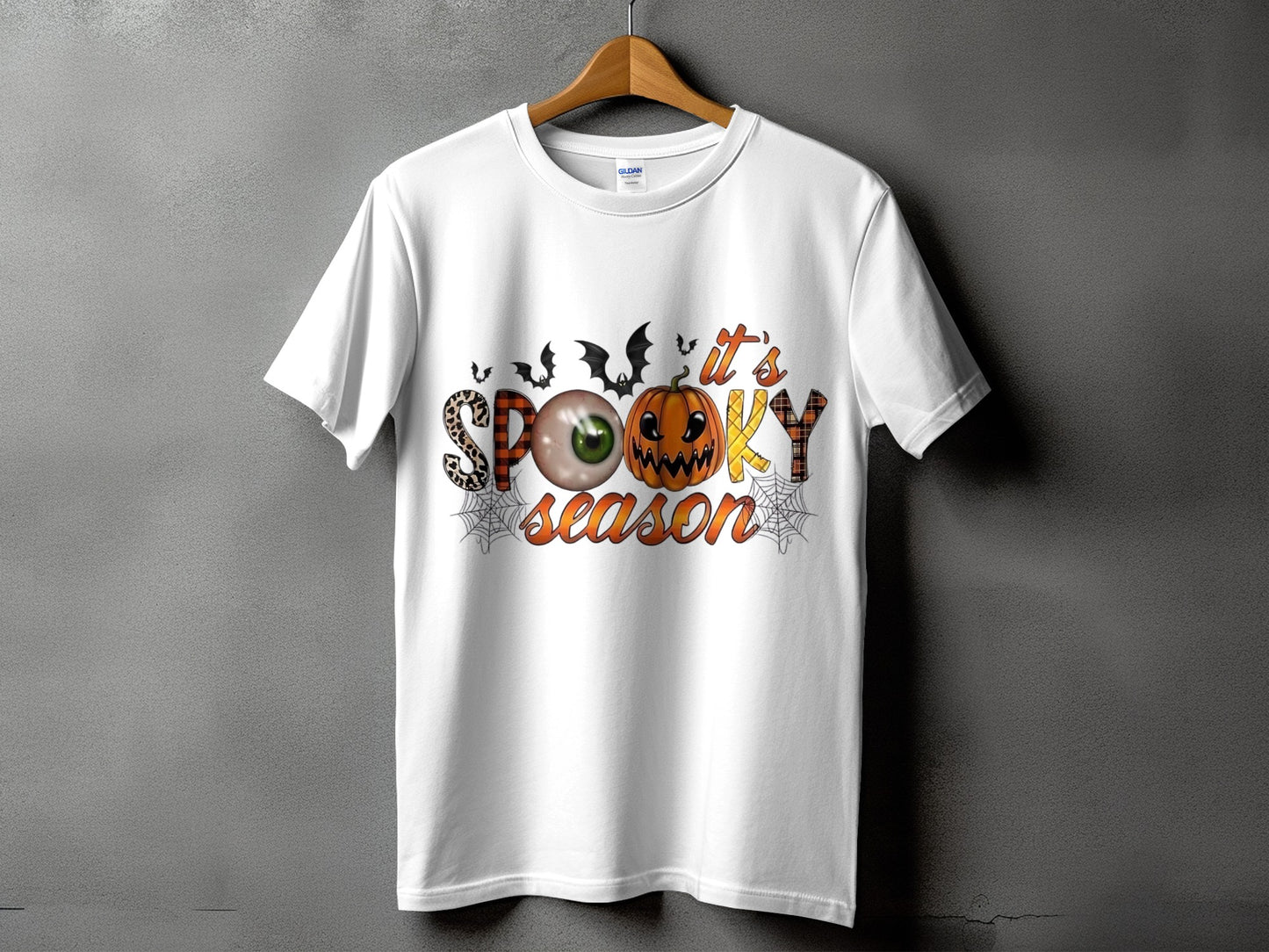 White t-shirt with "it's SPOOKY season" Halloween graphic featuring pumpkin and eyeball.