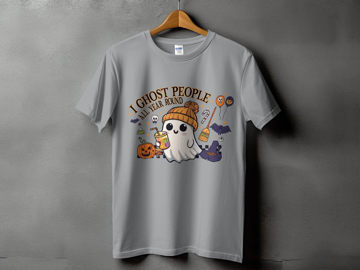 T-shirt with a cute ghost character, pumpkin, and Halloween decorations with text "I GHOST PEOPLE ALL YEAR ROUND".