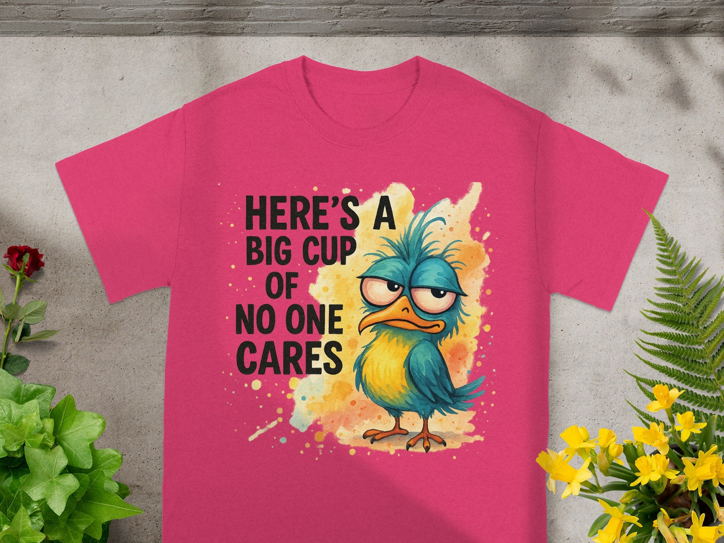 Pink t-shirt with cartoon bird and text "Here's a big cup of no one cares."