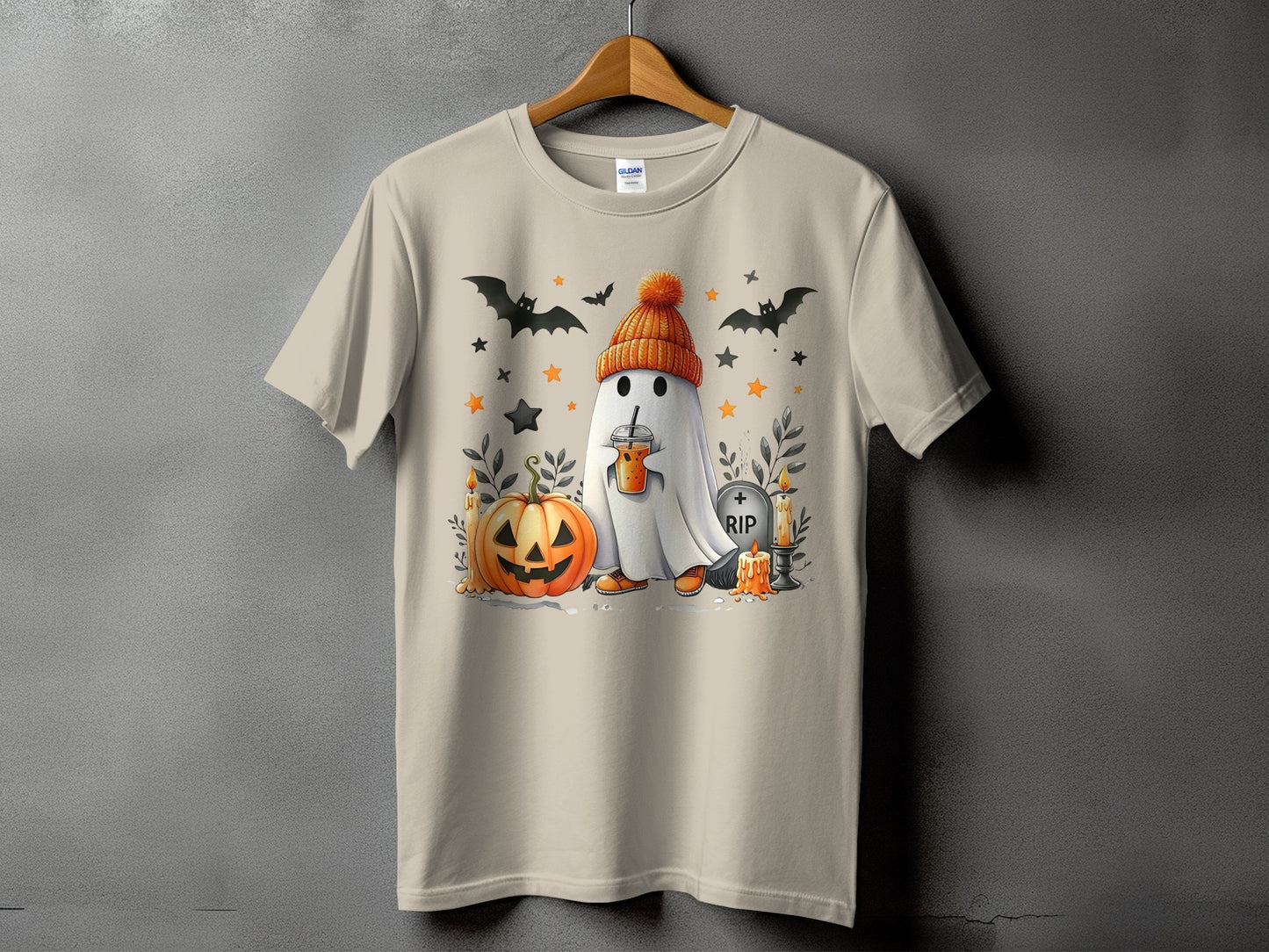 Ghost with pumpkin, bats, and RIP tombstone on a tan t-shirt.