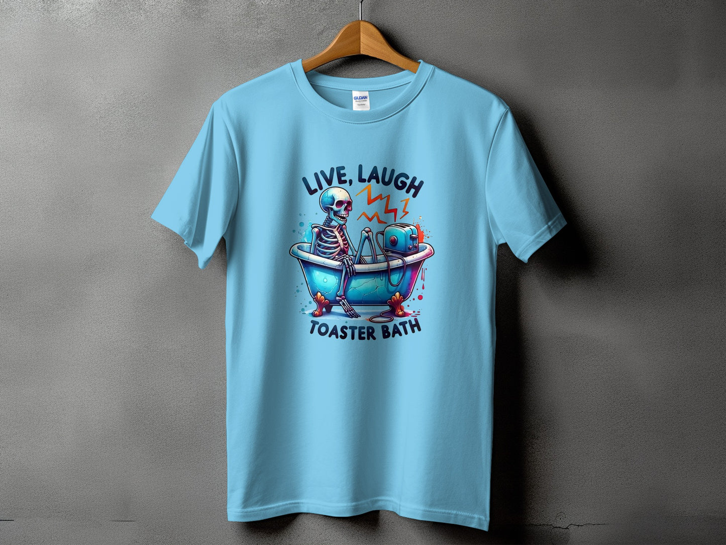 Light blue t-shirt with skeleton in bathtub and toaster, text reads "LIVE, LAUGH, TOASTER BATH".