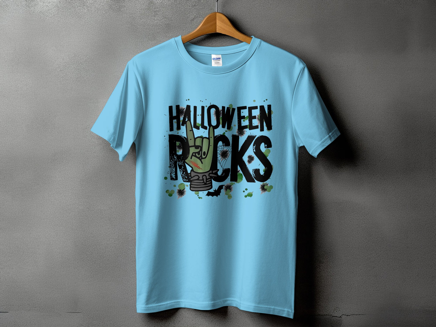 Light blue t-shirt with black "HALLOWEEN ROCKS" text and a green hand making a rock on gesture.