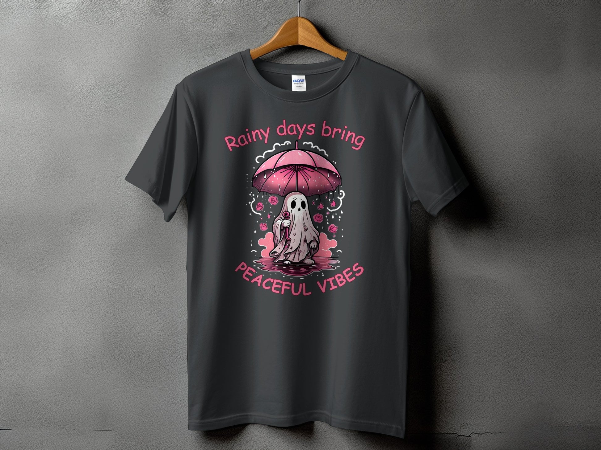 Dark gray t-shirt with pink text "Rainy days bring peaceful vibes" and a ghost under an umbrella.