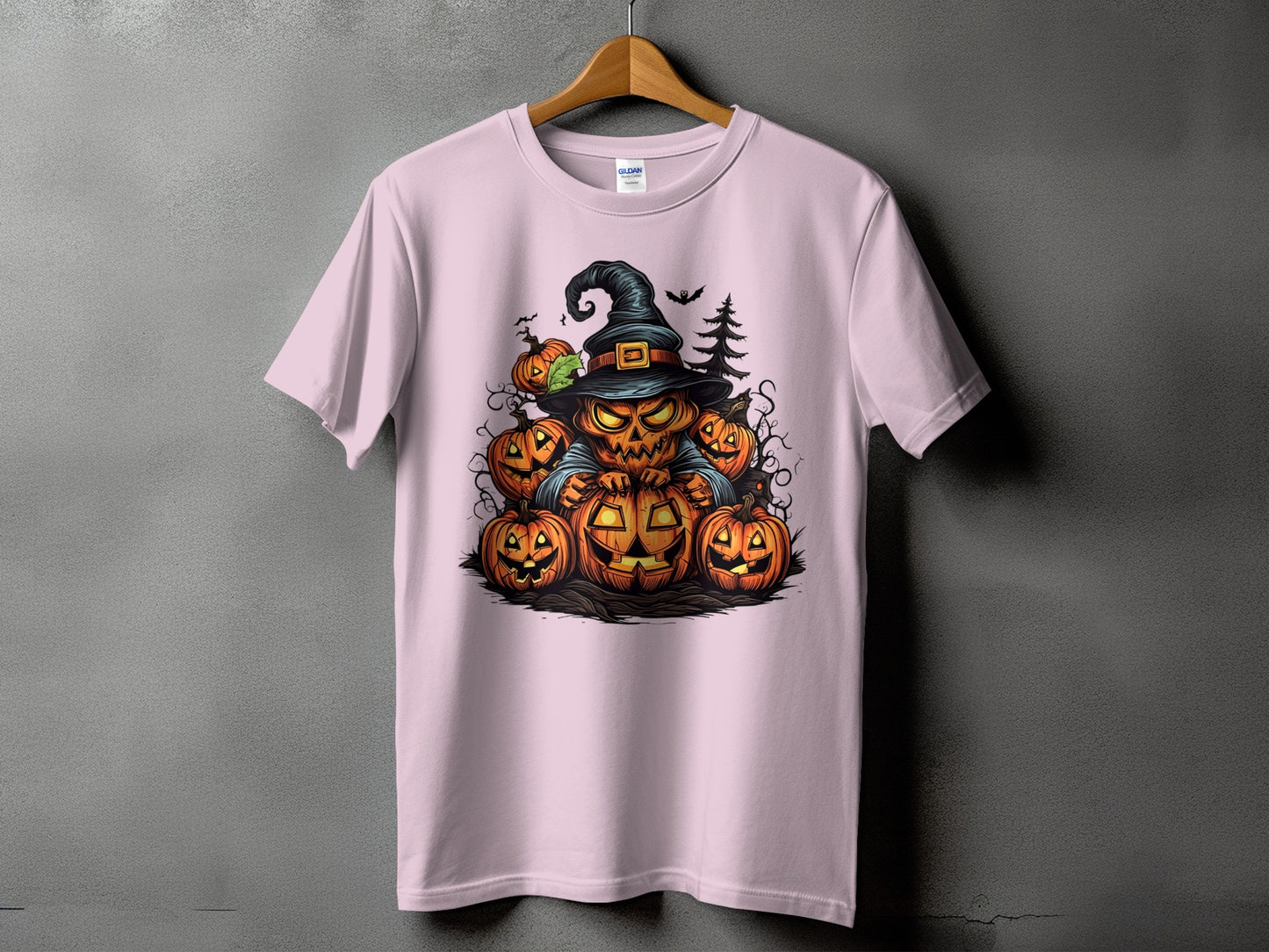 Pink t-shirt with a Halloween graphic featuring a jack-o'-lantern character and pumpkins.