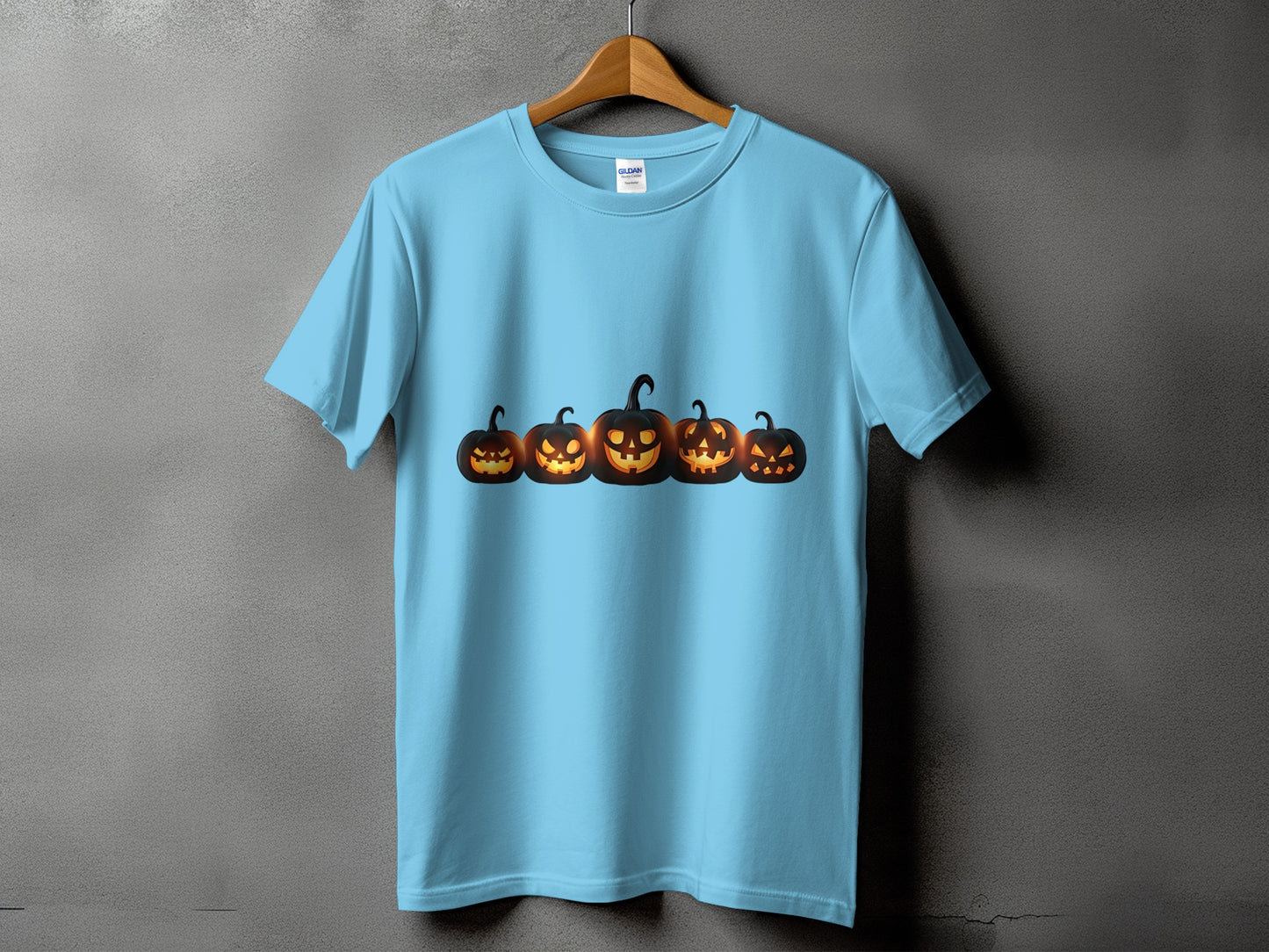 Light blue t-shirt with five glowing jack-o'-lanterns across the chest.