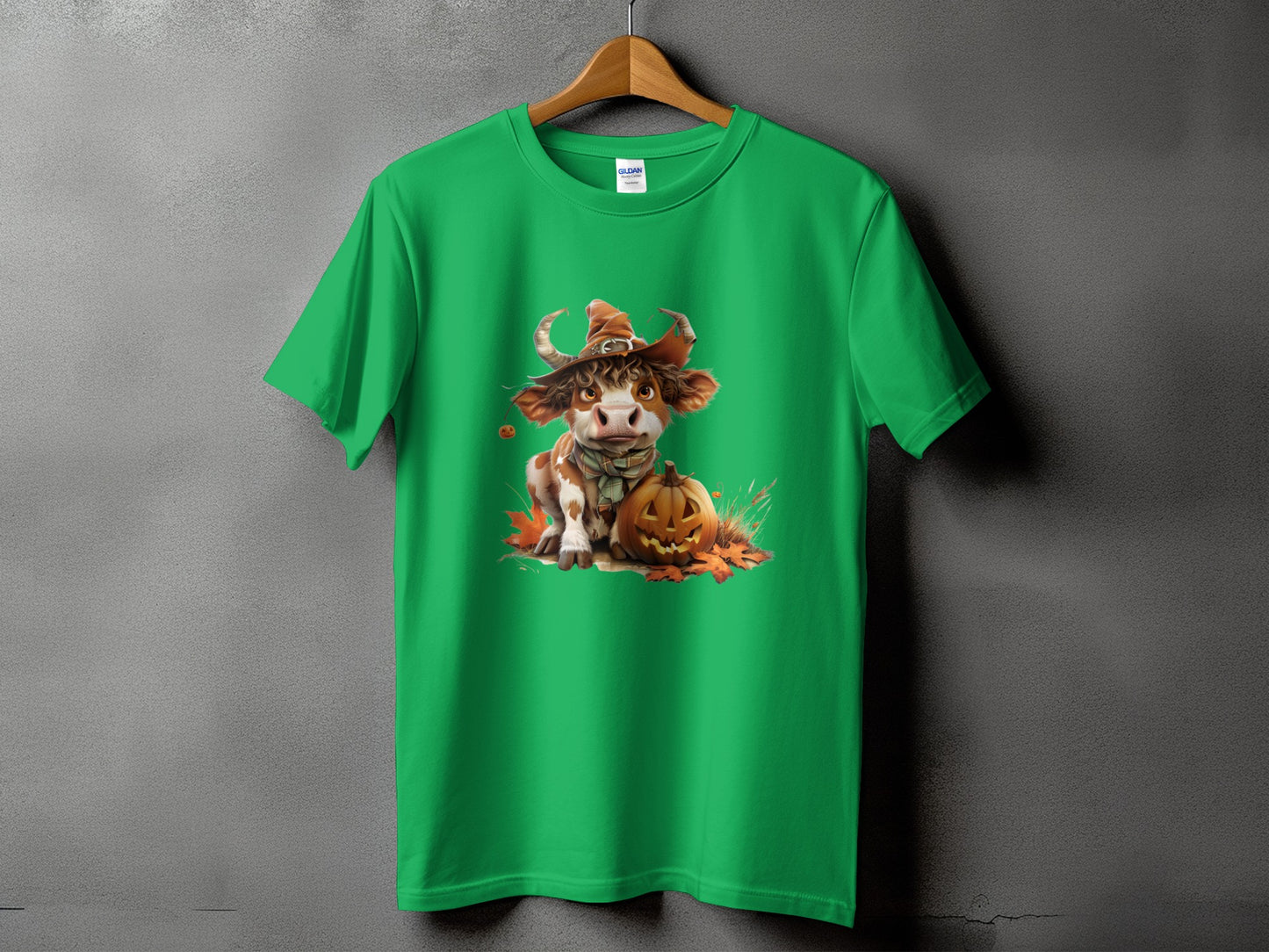 Green t-shirt with a cute cow in a witch hat and a Halloween pumpkin graphic.