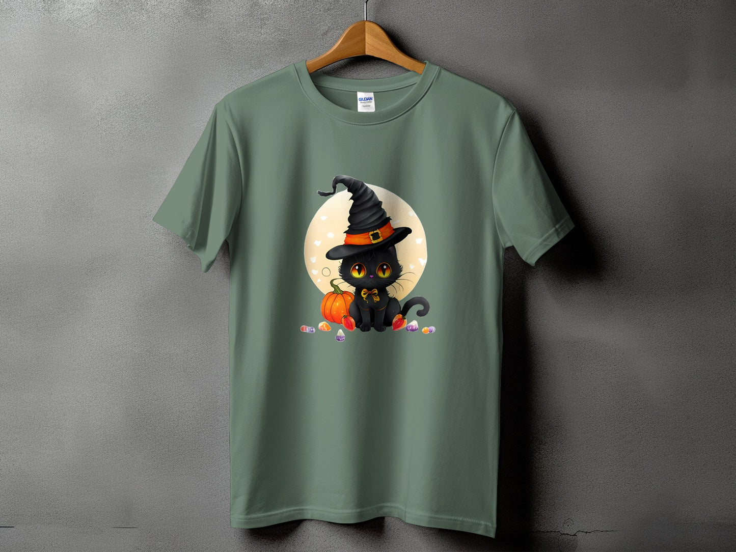 Green t-shirt with a cute black cat wearing a witch hat and sitting next to a pumpkin.