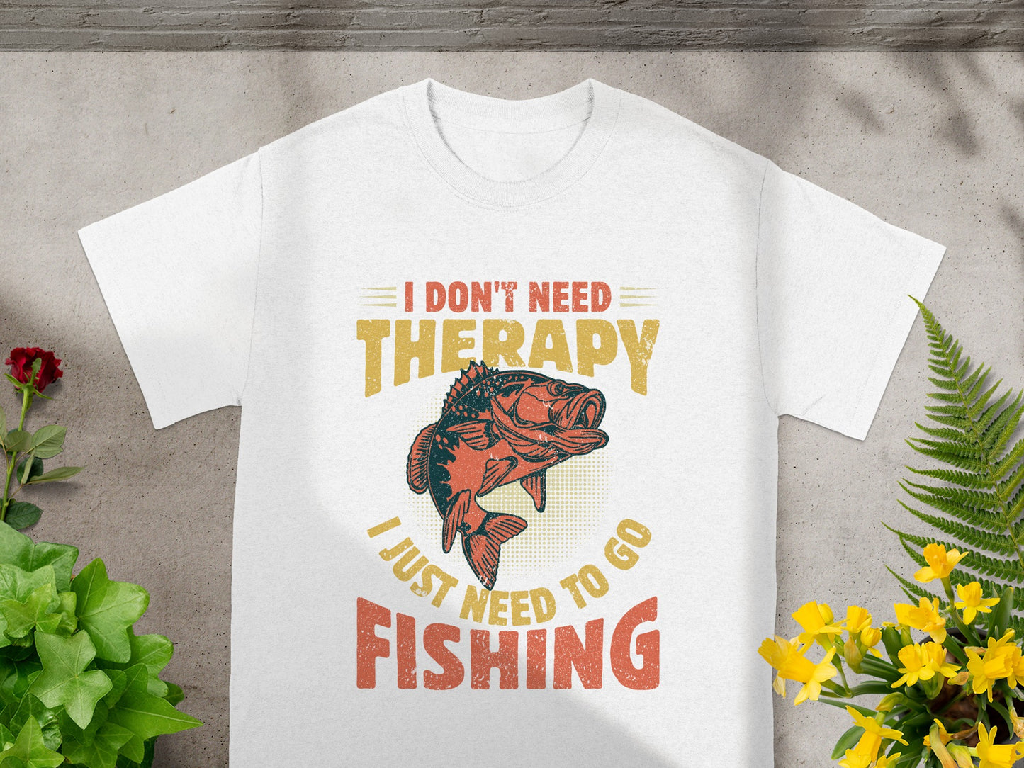 White t-shirt with a bass fish graphic and text that reads "I don't need therapy, I just need to go fishing."
