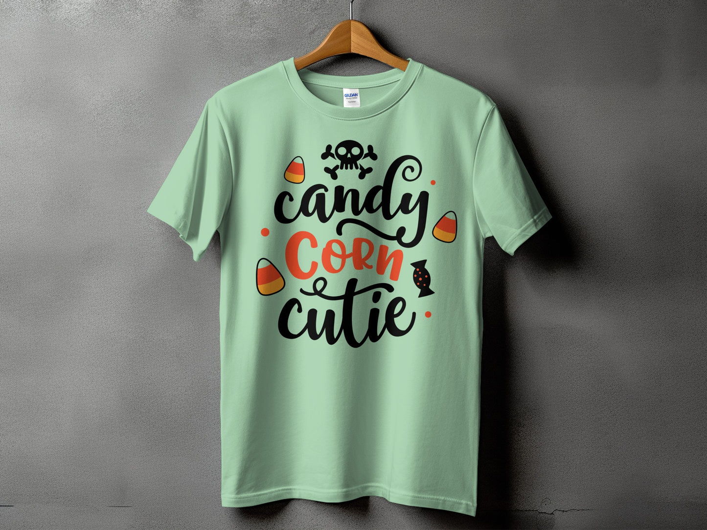 Light green t-shirt with black and orange "candy corn cutie" text and Halloween graphics.