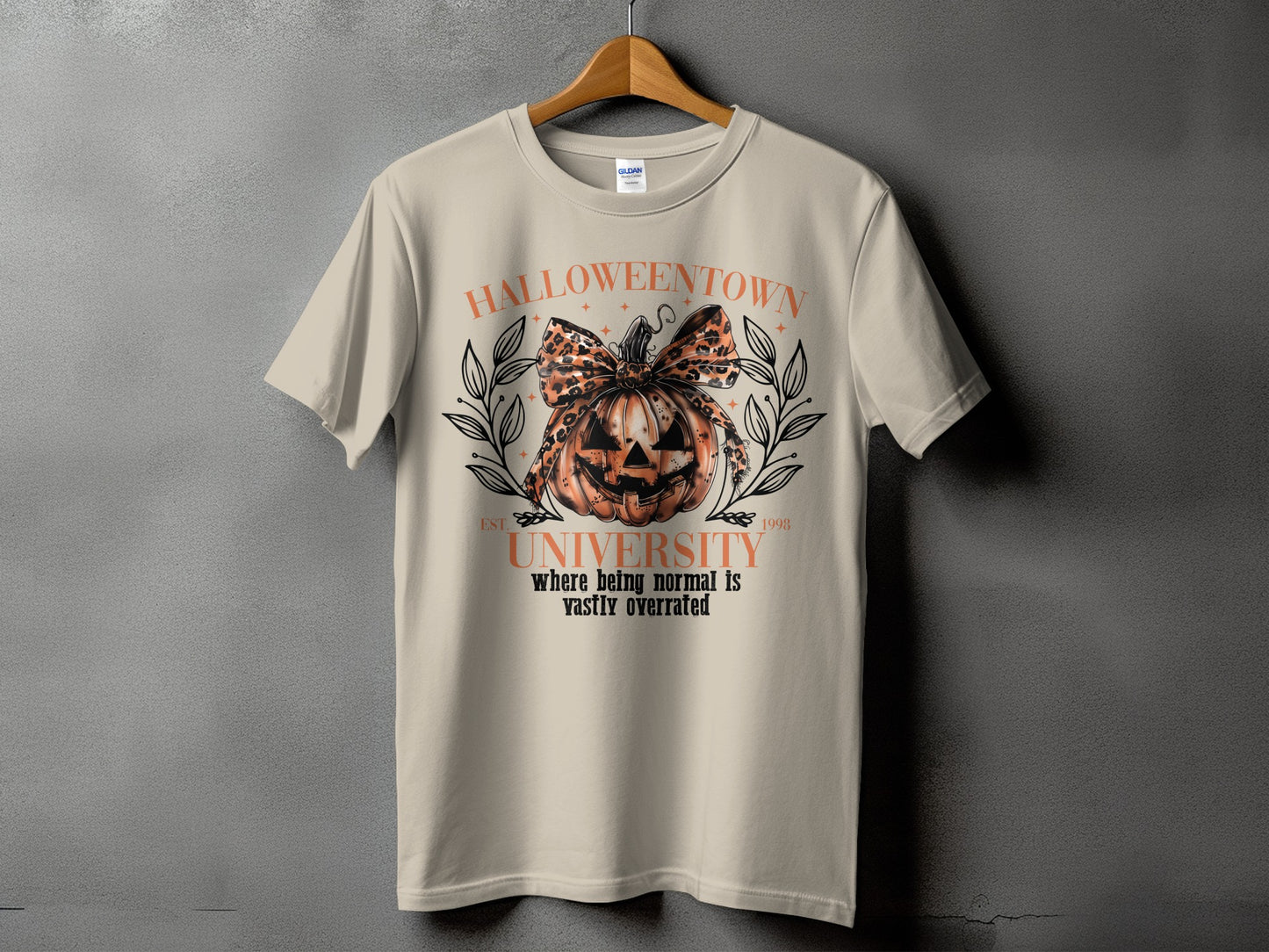 Light beige t-shirt with Halloween town university graphic on front.