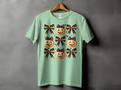Mint green t-shirt with scattered jack-o'-lanterns and bows Halloween pattern.