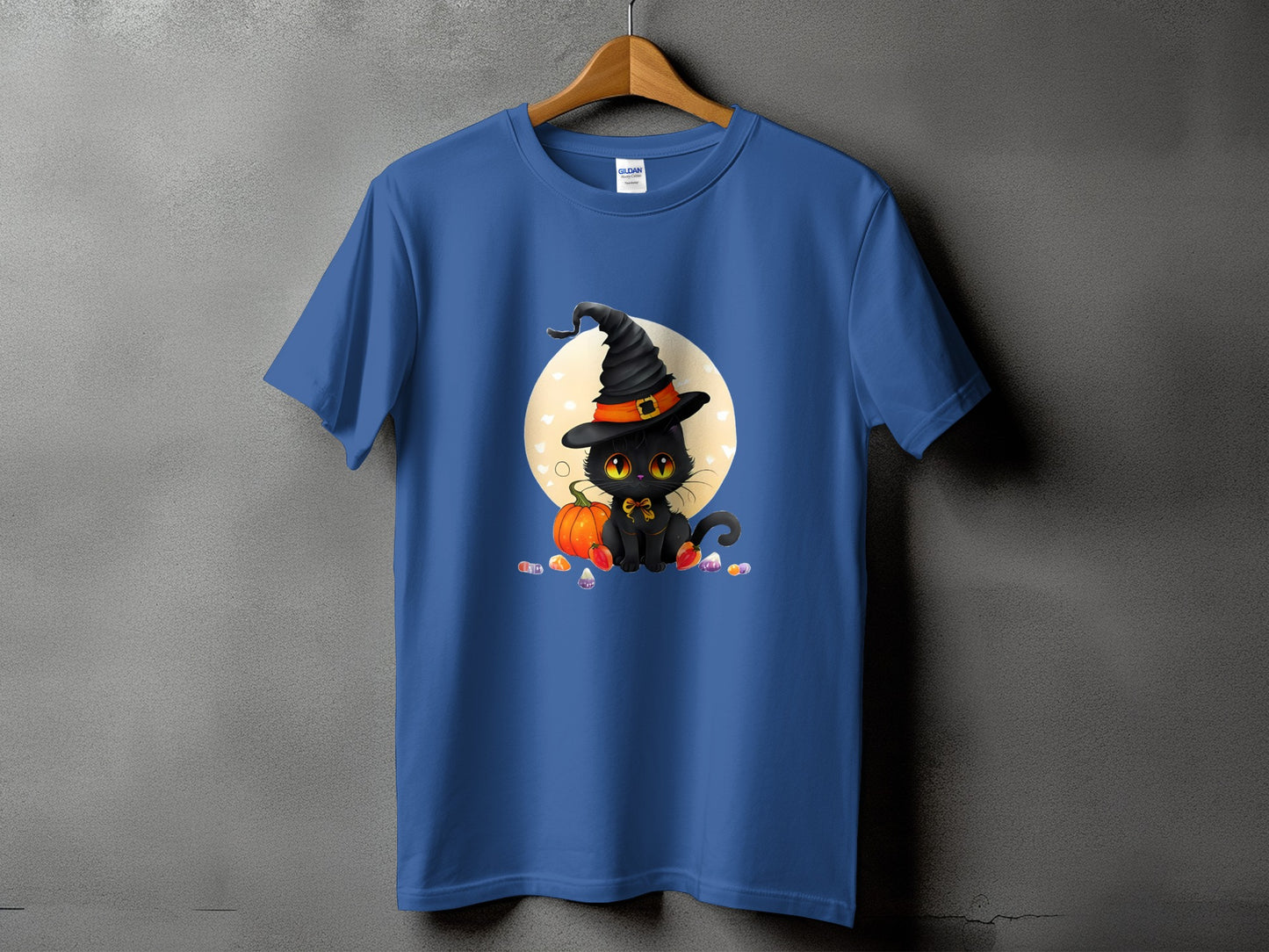 Blue t-shirt with a black cat wearing a witch hat and sitting by a pumpkin.