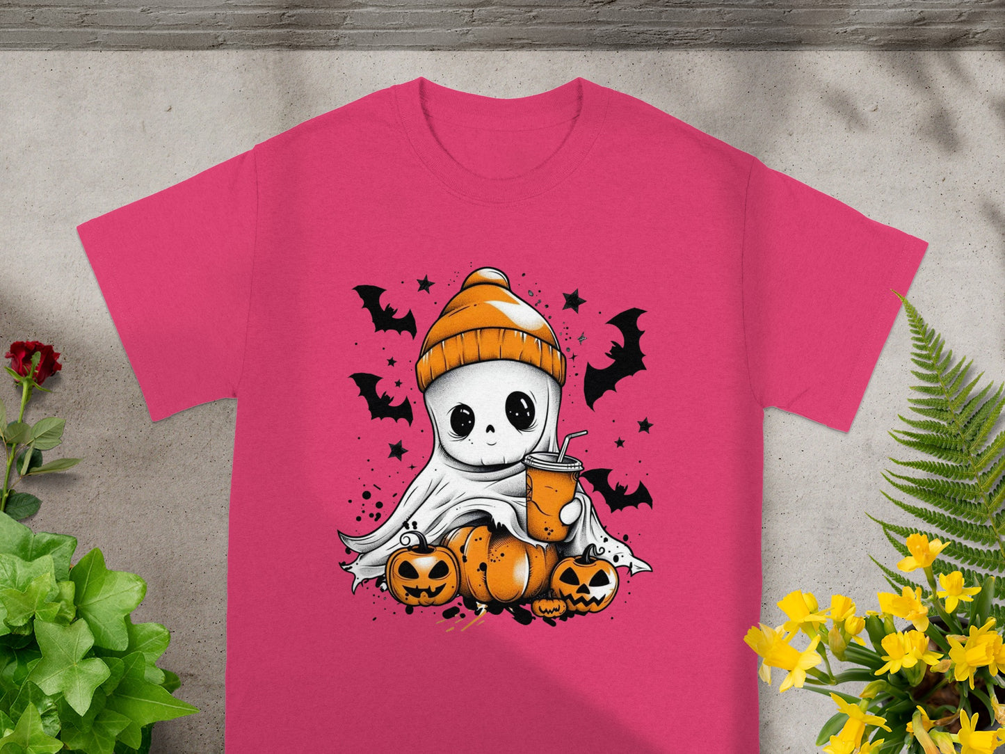 Pink t-shirt with a cartoon ghost, pumpkins, bats, and a drink graphic.