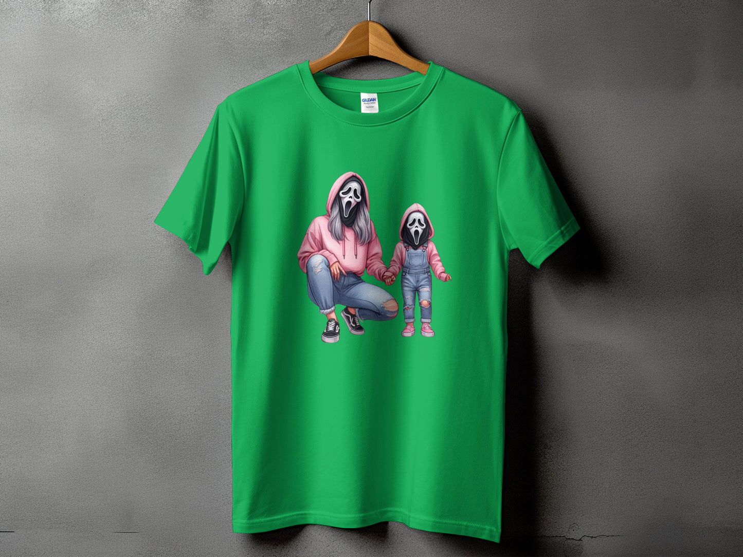 Green t-shirt with graphic of a woman and child wearing ghost masks.