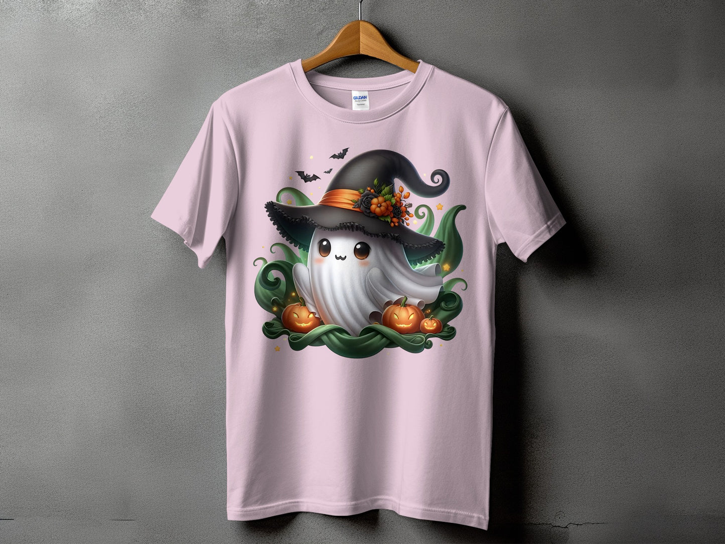 Pink t-shirt with a ghost wearing a witch hat, surrounded by pumpkins and bats.