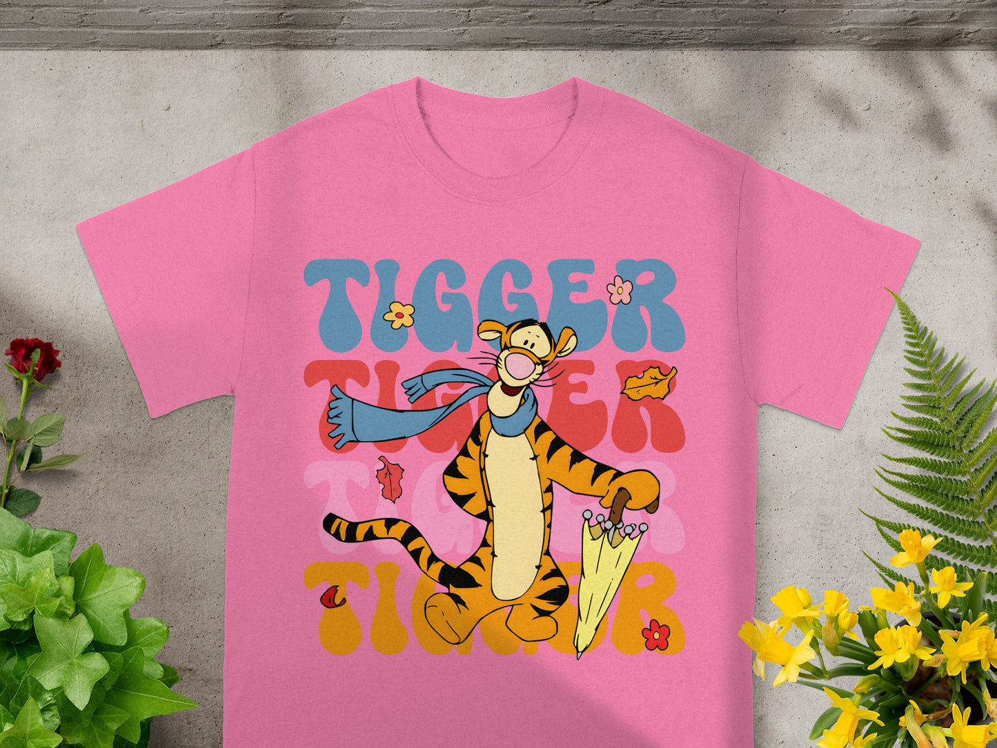 Pink t-shirt with Tigger holding an umbrella and wearing a scarf.