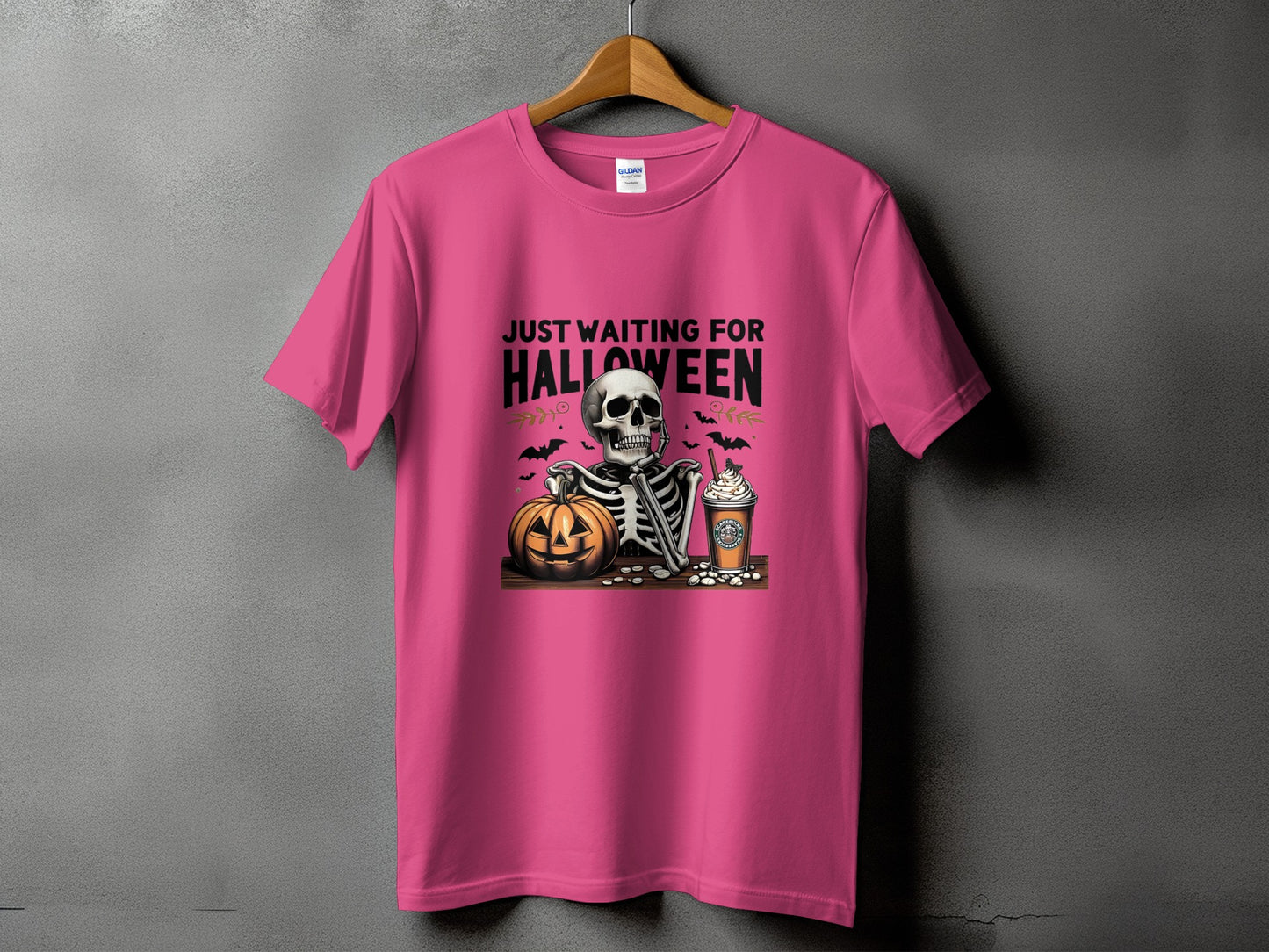Pink t-shirt with graphic that reads "Just Waiting For Halloween" and features skeleton, pumpkin, and coffee cup.