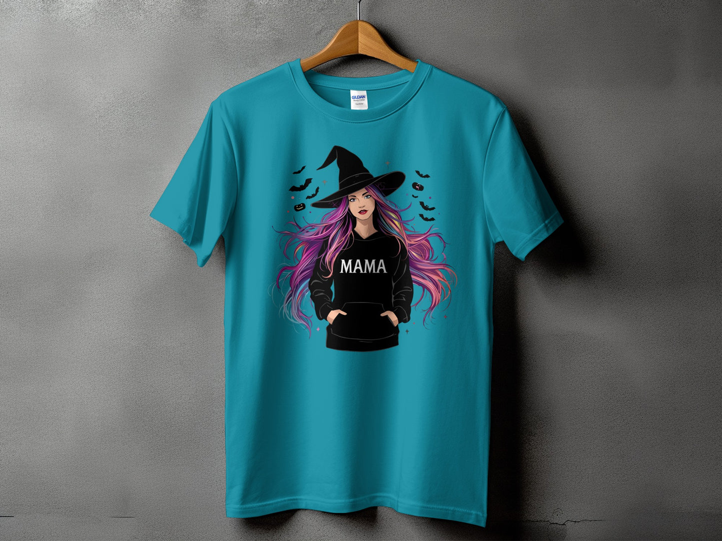 Teal t-shirt with a graphic of a witch with colorful hair and the word MAMA.