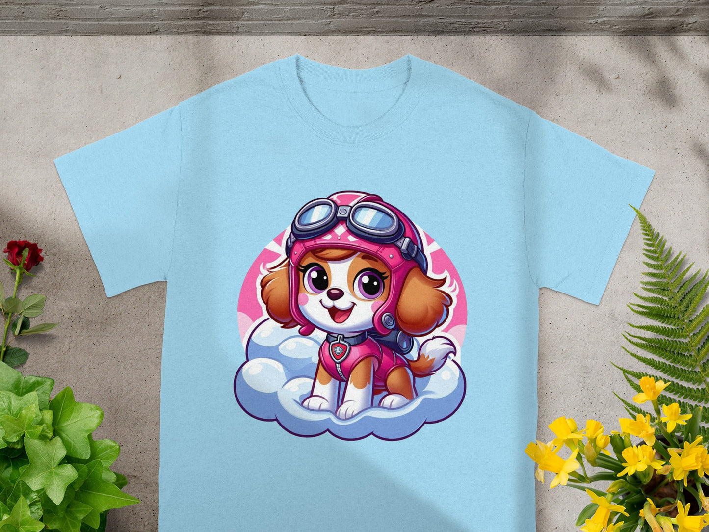 Sky dog wearing pilot goggles on a cloud, on a light blue t-shirt.
