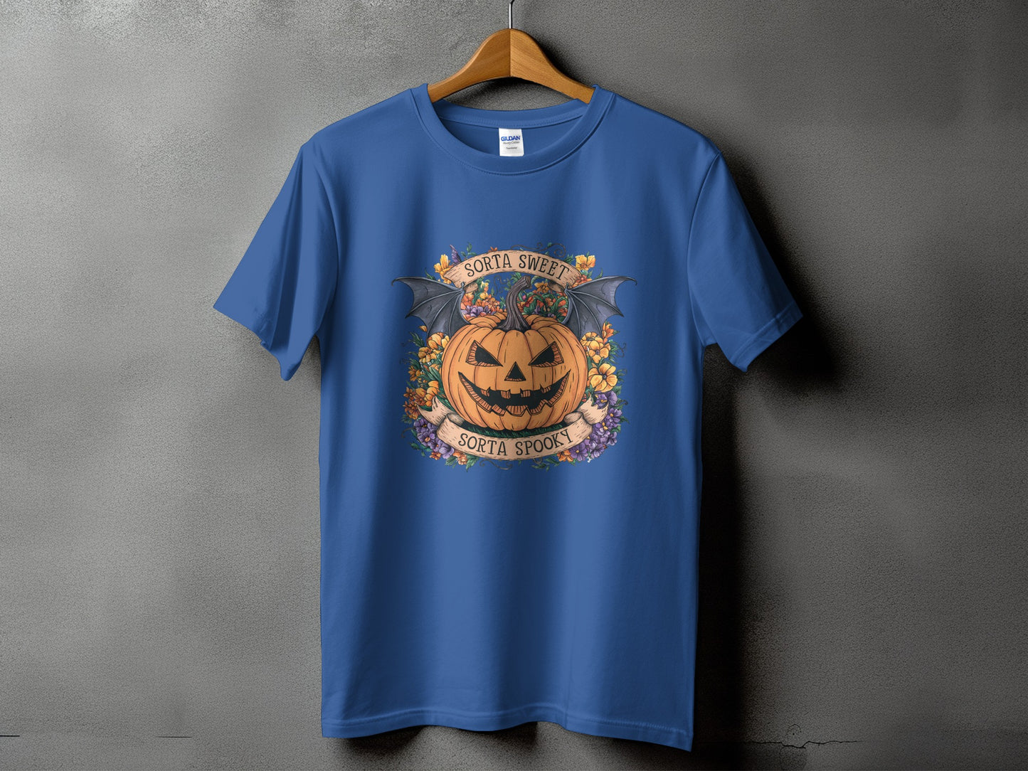 Blue t-shirt with a Halloween design of a jack-o'-lantern, bat wings, and flowers.