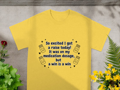 Yellow t-shirt with text: "So excited I got a raise today! It was on my medication dosage, but a win is a win."