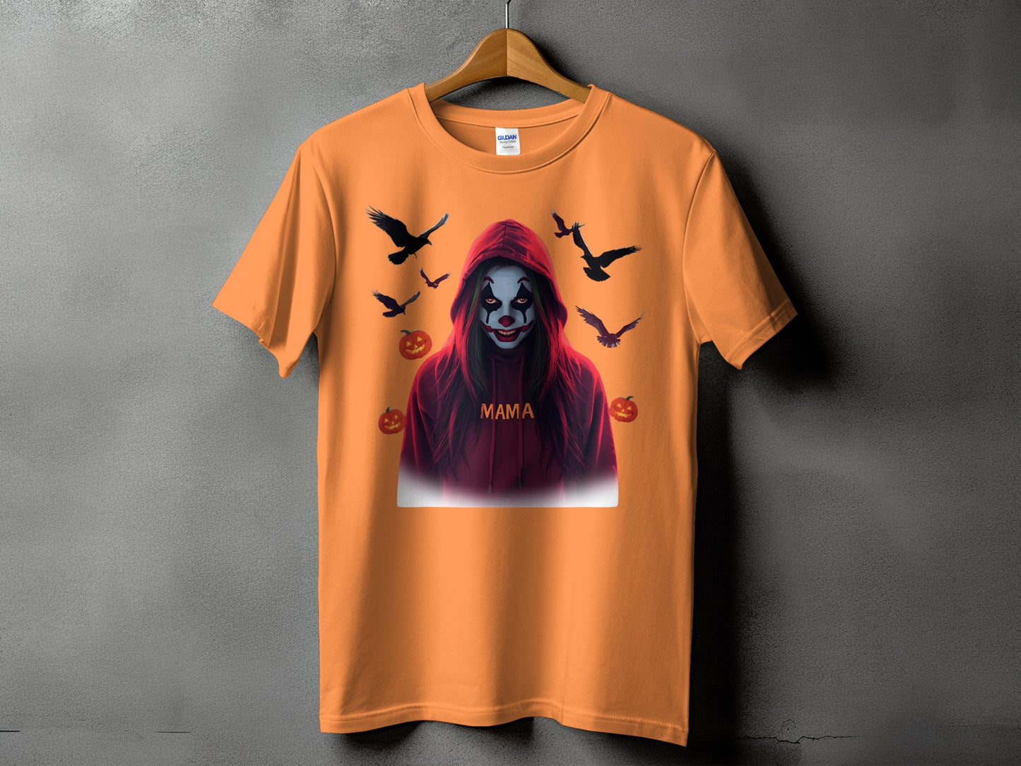 Orange t-shirt with a spooky clown graphic, crows, and pumpkins, and the word "Mama".