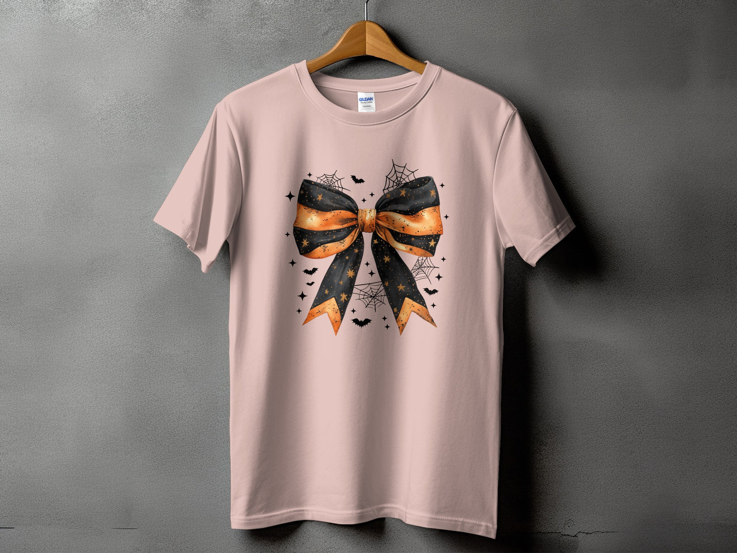 Pink t-shirt with a Halloween-themed bow graphic featuring bats and cobwebs.