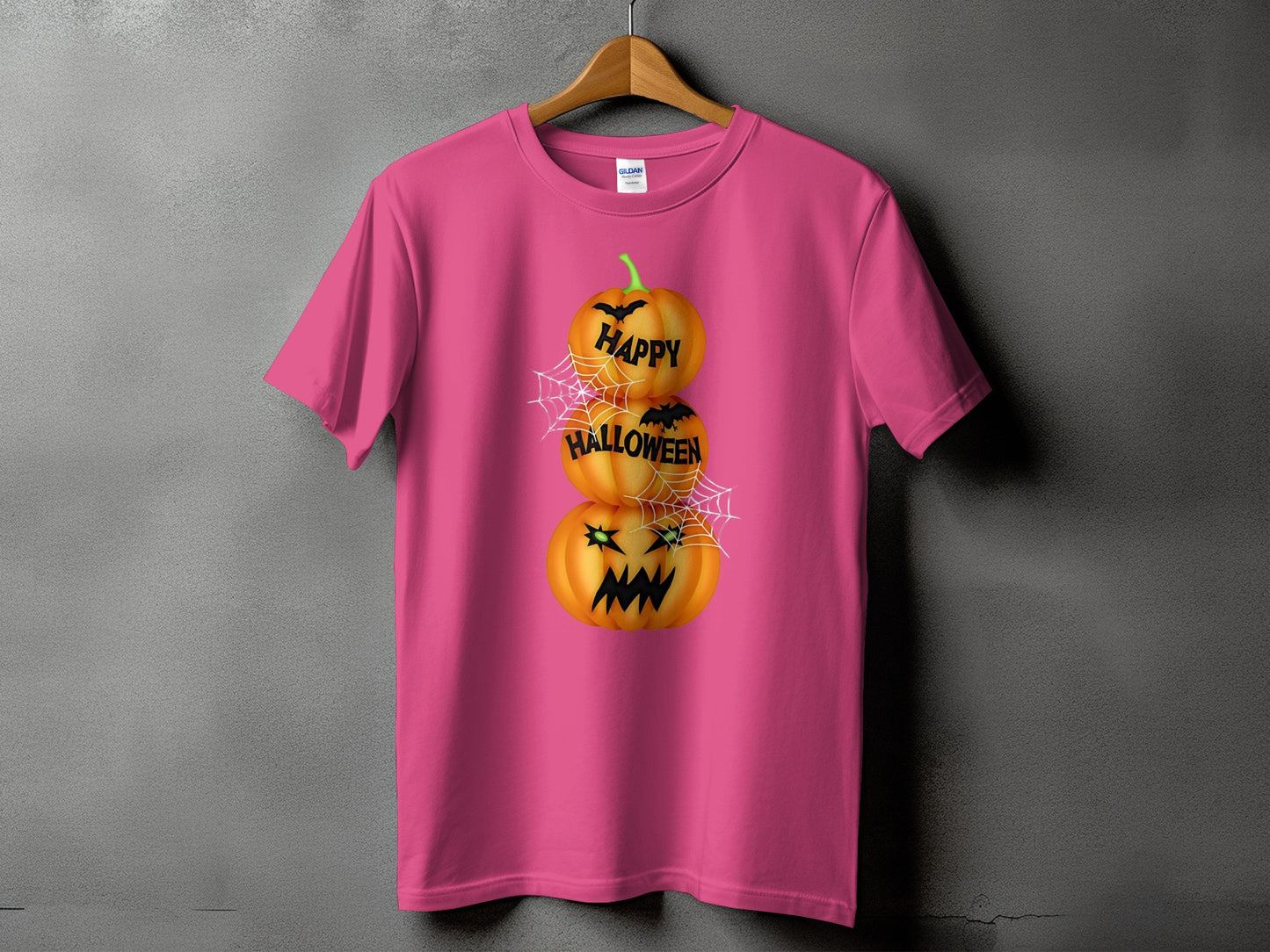 Pink t-shirt with stacked pumpkins reading "HAPPY HALLOWEEN" and spiderwebs.