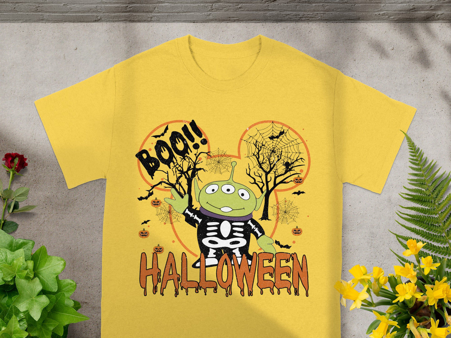 Yellow t-shirt with Halloween graphic featuring an alien in a skeleton costume.