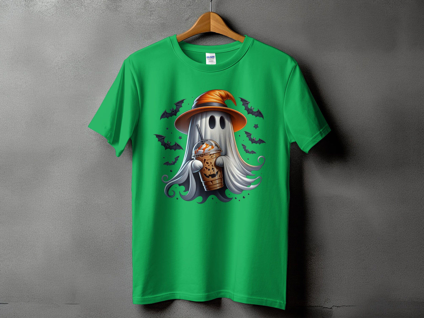 Green t-shirt with a cartoon ghost wearing a witch hat and holding a pumpkin spice latte.