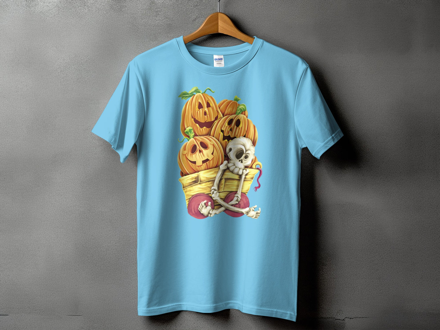 Light blue t-shirt with Halloween pumpkins, a skeleton, and a wagon graphic.